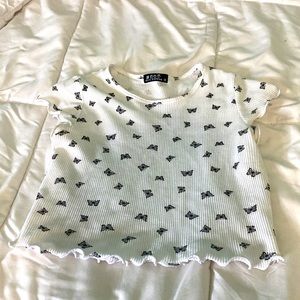 this is a crop top and it is white with black butterflies on it
